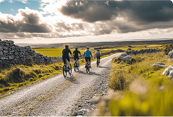A group of people riding bikes down a dirt road